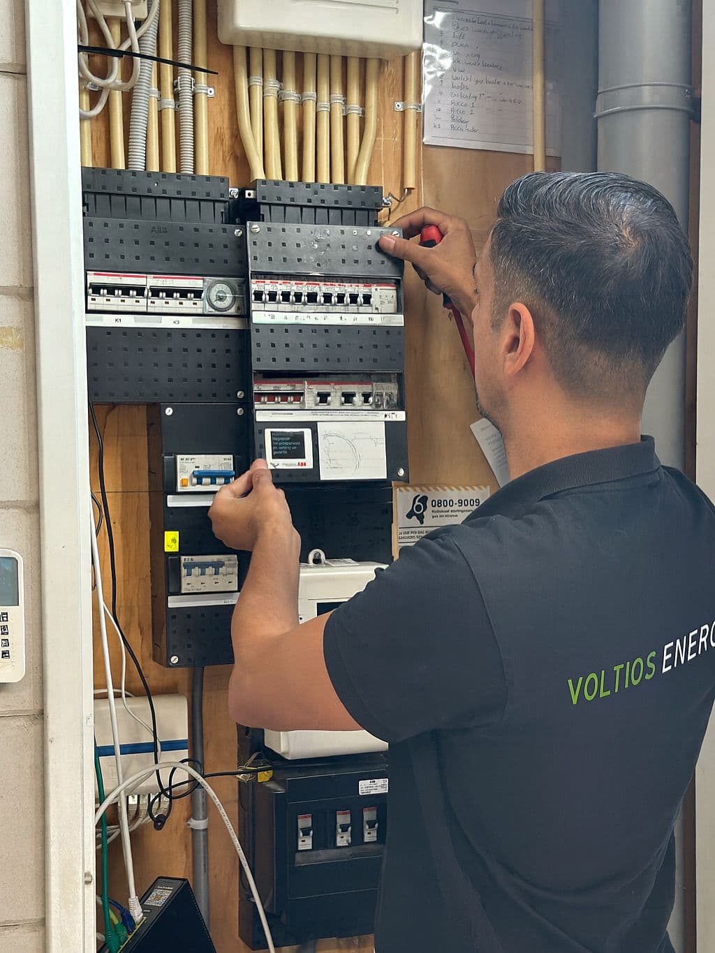 Voltios medewerker bij een groepenkast